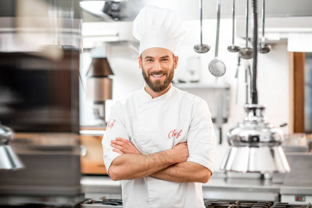 Portrait of a handsome, positive chef cook beaming in the bustling restaurant kitchen, proudly plating Mumbai’s best street food with a sizzling vada pav masterpiece!